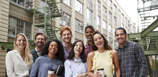 De psychologie achter een succesvol teamuitje: waarom samenwerken beter gaat na een dagje uit Collega's staan lachend samen op de foto