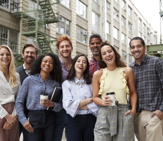 De psychologie achter een succesvol teamuitje: waarom samenwerken beter gaat na een dagje uit Collega's staan lachend samen op de foto