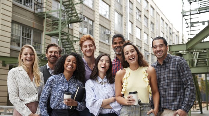 De psychologie achter een succesvol teamuitje: waarom samenwerken beter gaat na een dagje uit Collega's staan lachend samen op de foto