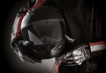 Motorkleding kiezen: jouw stijl en veiligheid in één pakket Motorrijder houdt helm in handen met handschoenen