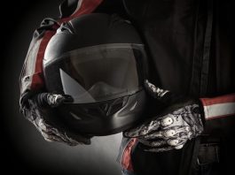 Motorkleding kiezen: jouw stijl en veiligheid in één pakket Motorrijder houdt helm in handen met handschoenen