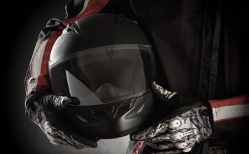 Motorkleding kiezen: jouw stijl en veiligheid in één pakket Motorrijder houdt helm in handen met handschoenen