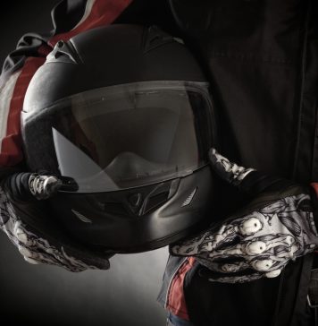 Motorkleding kiezen: jouw stijl en veiligheid in één pakket Motorrijder houdt helm in handen met handschoenen