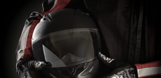 Motorkleding kiezen: jouw stijl en veiligheid in één pakket Motorrijder houdt helm in handen met handschoenen