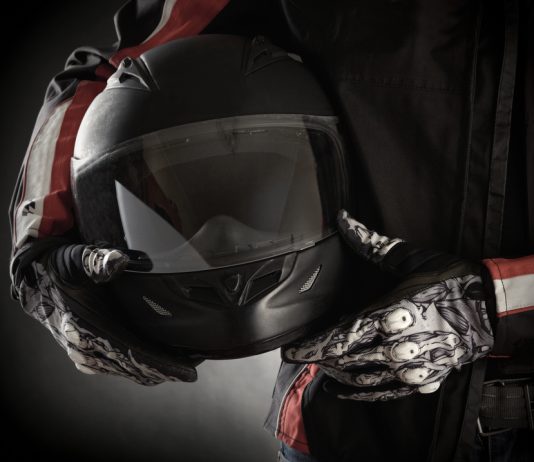 Motorkleding kiezen: jouw stijl en veiligheid in één pakket Motorrijder houdt helm in handen met handschoenen