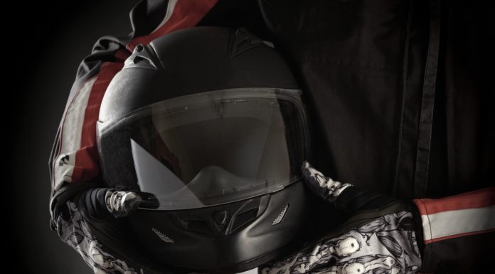 Motorkleding kiezen: jouw stijl en veiligheid in één pakket Motorrijder houdt helm in handen met handschoenen